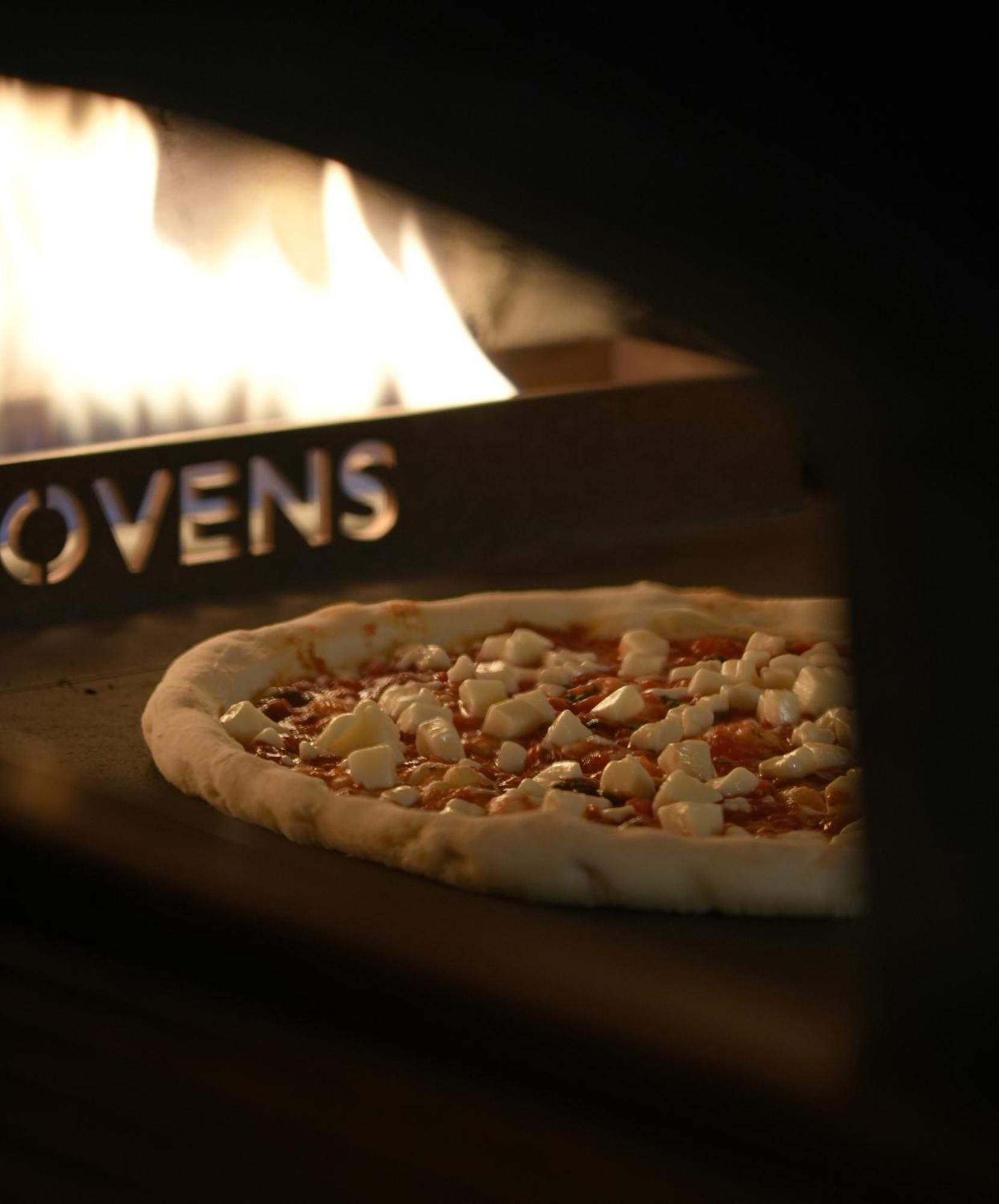 Fairmont Riadh Exterior foto A pizza in a wood-fired oven