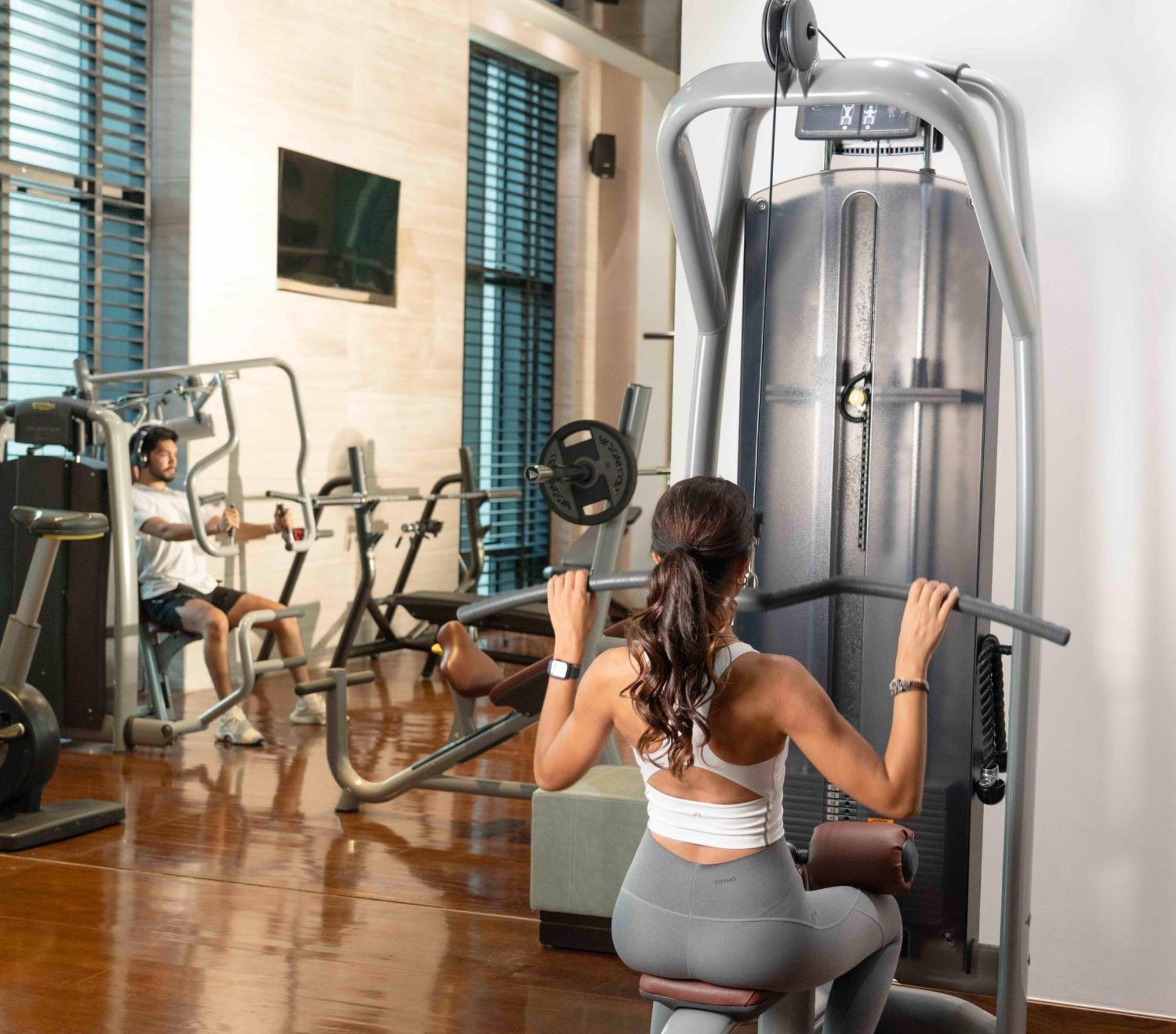 Fairmont Riadh Exterior foto A woman using a lat pulldown machine